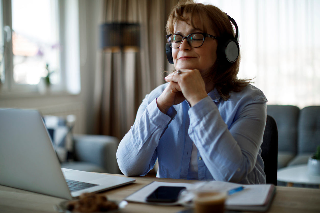 Lady with blue shirt and glasses, very calm with headphones on head